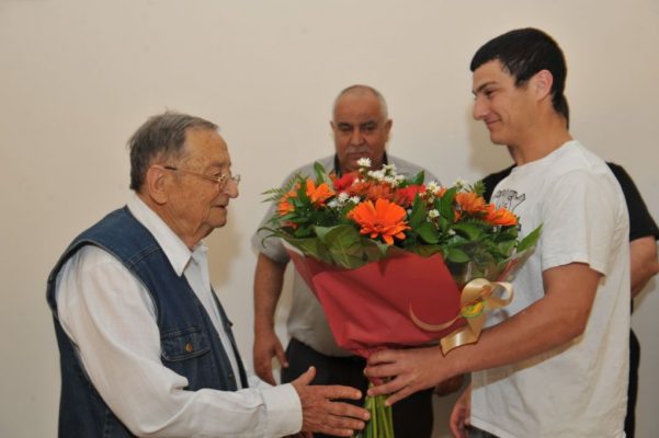 556588-עזריה אלון מקבל זר פרחים מחניך תנועת הנוער